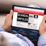 Person reading tablet with headline Scandal Unfolds