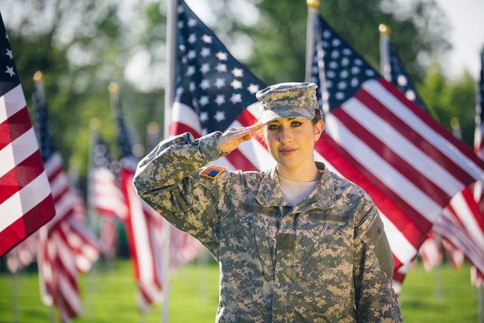 1081070213 Soldier saluting in front of American flags outdoors.