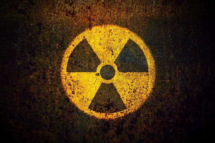 1082372921 Yellow radiation warning symbol on rusty metal surface.