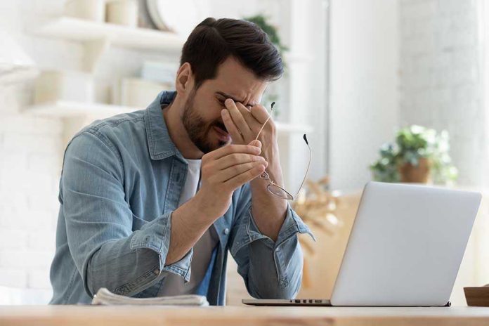 1575539137 Man rubbing eyes holding glasses near laptop