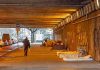 People walk under a bridge with homeless encampment