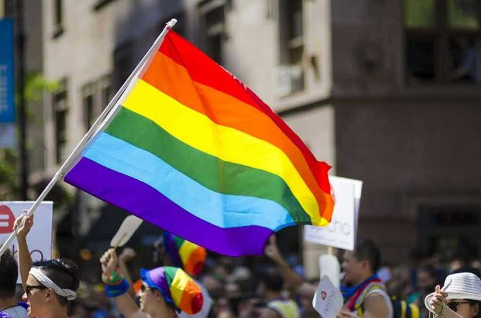 522918778 People holding and waving a rainbow flag.