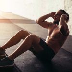 Man performing sit ups in a gym setting