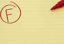 Yellow notepad with a red marker and a circled grade F