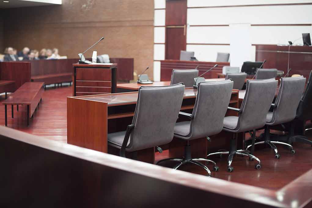Empty courtroom with desks and chairs.