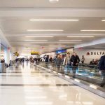 People walking through a busy airport terminal.