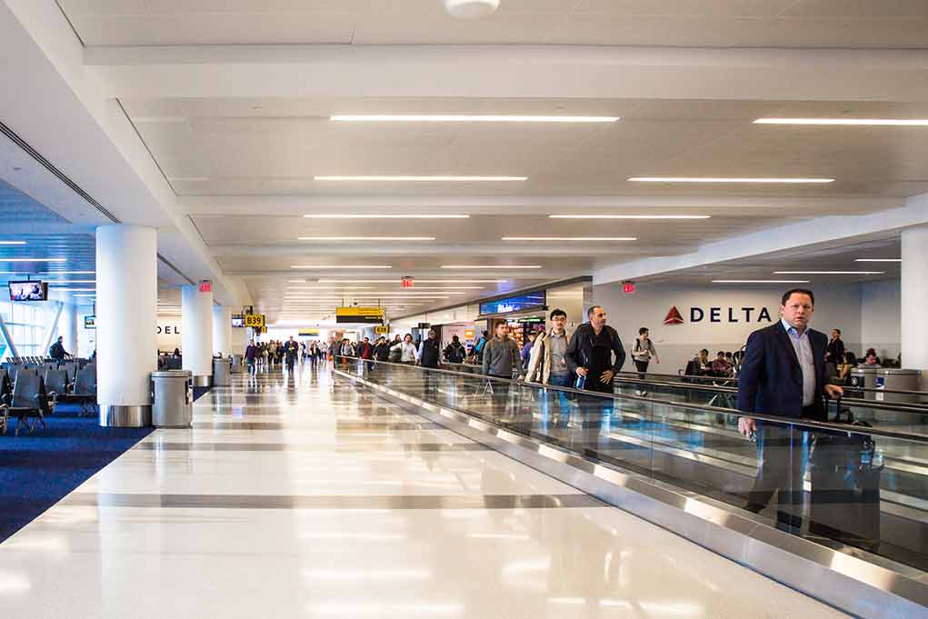 People walking through a busy airport terminal.