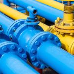 How Russian Gas Withdrawal Shifts European Energy Dynamics And Alliances Blue and yellow industrial gas pipes with valves.