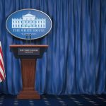 White House’s Fresh Approach On Inclusive Media Under Karoline Leavitt Empty White House podium and American flag.
