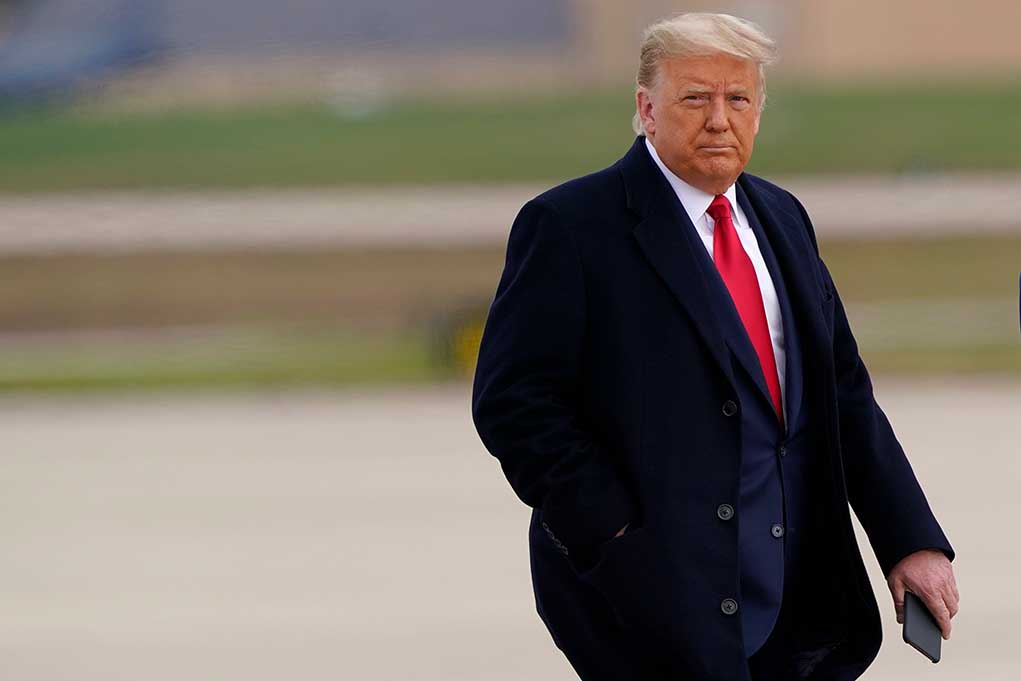 1876973395 featured image Man in coat holding smartphone, outdoors.