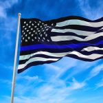 Debate Over First Amendment Rights and the Thin Blue Line Flag Unfolds Black and white flag with blue stripe flying