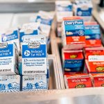 Milk cartons in a refrigerated display case.