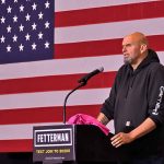 Can Fetterman Bridge Pennsylvania’s Political Divide? Person speaking at podium with American flag backdrop