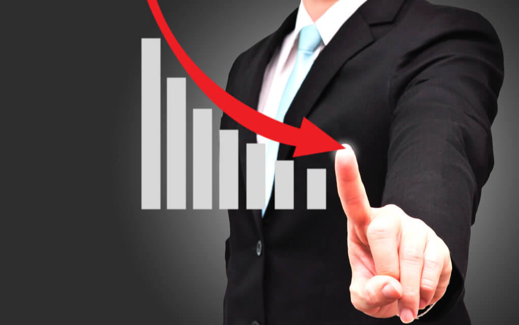 Businessman pointing at declining bar graph.