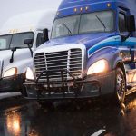 Driverless Trucks Transform Freight Dynamics In The Permian Basin Two trucks driving on a wet road.