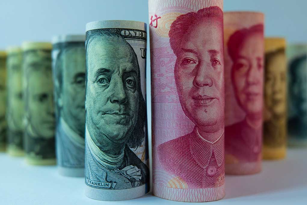 1064716769 featured image Rolled banknotes of US dollars and Chinese yuan