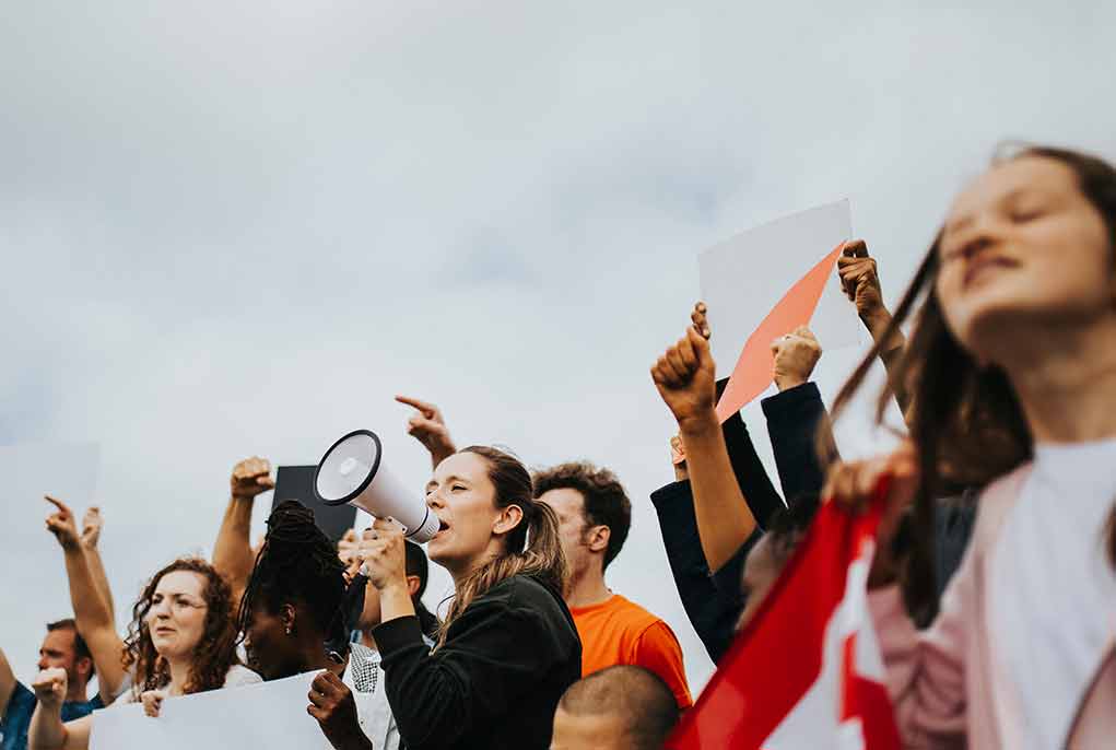 1235928748 featured image People protesting with signs and a megaphone outdoors