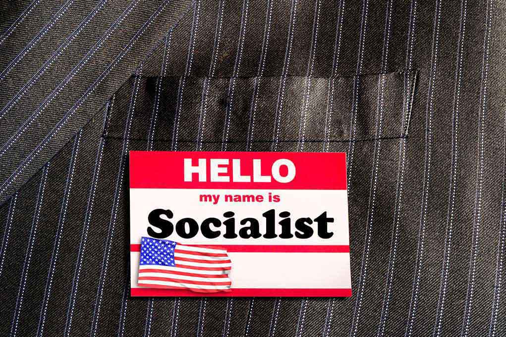1306450240 featured image "Hello my name is Socialist" name tag on suit.