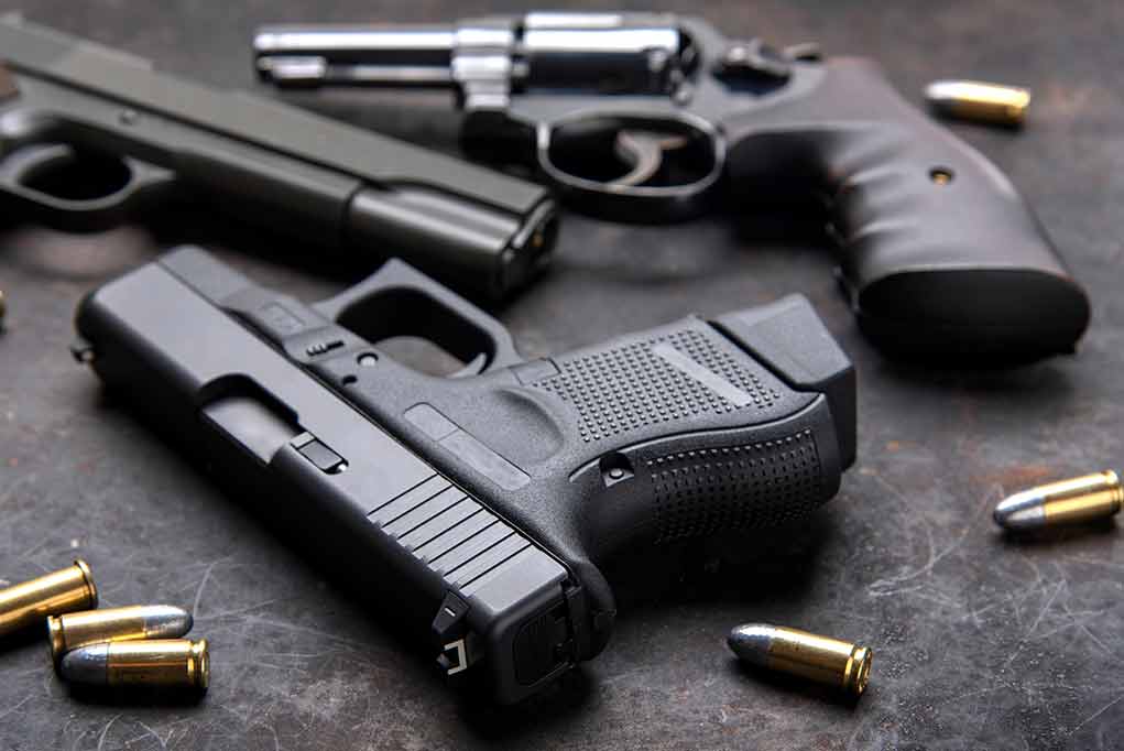 1458654980 featured image Pistols with scattered bullets on a dark surface