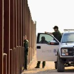 Cartel Innovations Are Changing The Game For Border Security Tactics Border patrol agents near a tall metal fence.