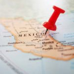President Sheinbaum Sends Warning To U.S. About Violating Mexican Sovereignty image of a map of Mexico,with a red pushpin applied to the middle of the country