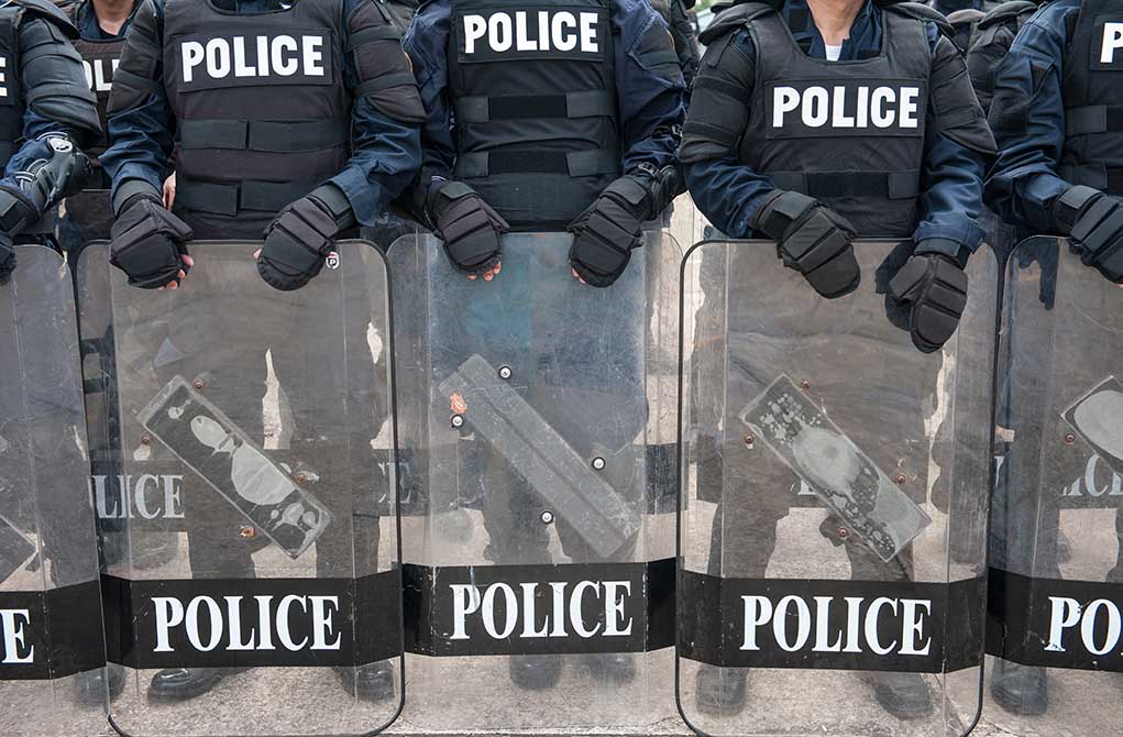 426281377 featured image Police officers in riot gear holding shields.