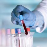 House Probes Ethical Concerns In Government-Funded Animal Research Gloved hand holding a test tube with blood.