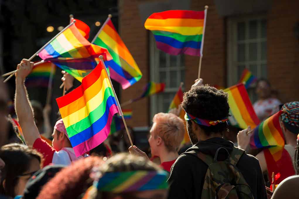 1099936808 featured image crowd of people waving rainbow colored flags