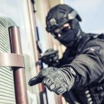 FBI Takes New Measures Against Growing Celebrity Swatting Threat SWAT officer reaching for door handle.