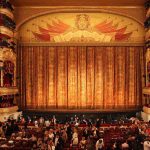 How Political Influence Led To “Hamilton” Cancellation At The Kennedy Center Ornate theater, grand curtain, audience seated below balconies.
