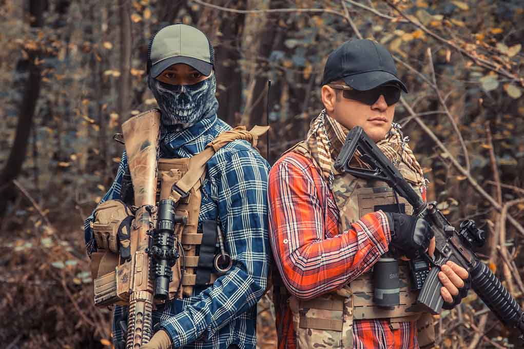 1691717854 featured image Two armed individuals in tactical gear in forest.