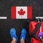 Trudeau’s Bold Stand Against U.S. Statehood Proposals For Canada Shoes and bag beside painted Canadian flag.