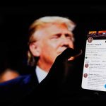 Florida Man’s Social Media Post Threatening Trump Lead To Arrest Person holding smartphone displaying Twitter profile page