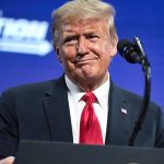 Trump’s Interview Rekindles JFK Assassination Theories Man in suit and red tie at podium.