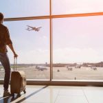 TSA Foils Unusual Smuggling At Newark Airport Traveler with luggage watches airplane take off at airport.