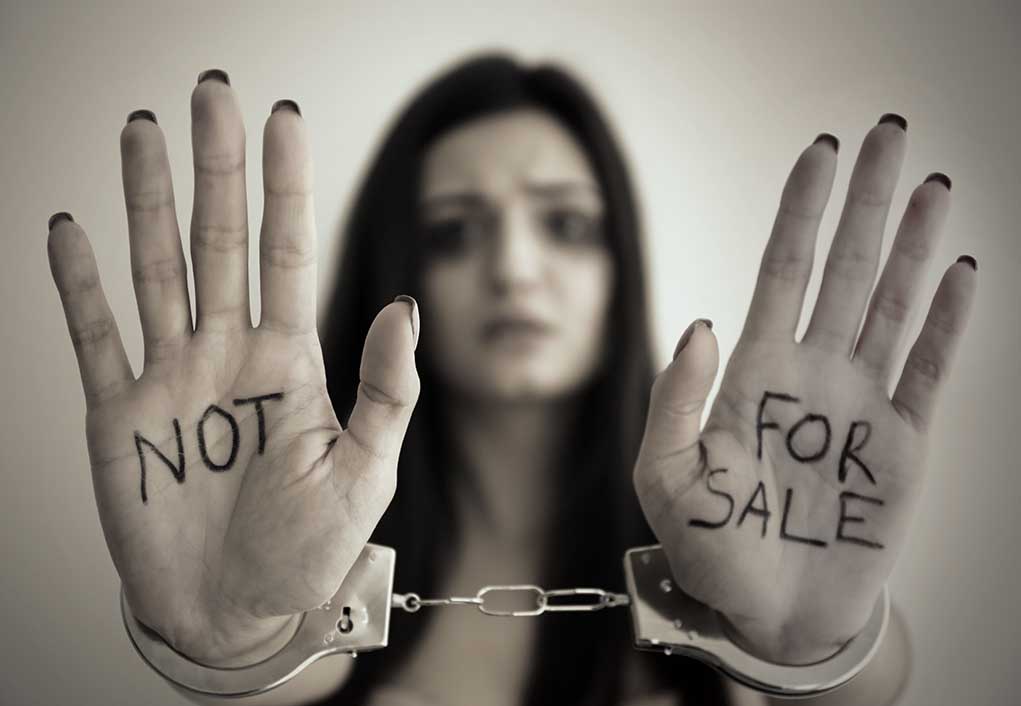 631031339 featured image Handcuffed woman shows "NOT FOR SALE" on her palms.