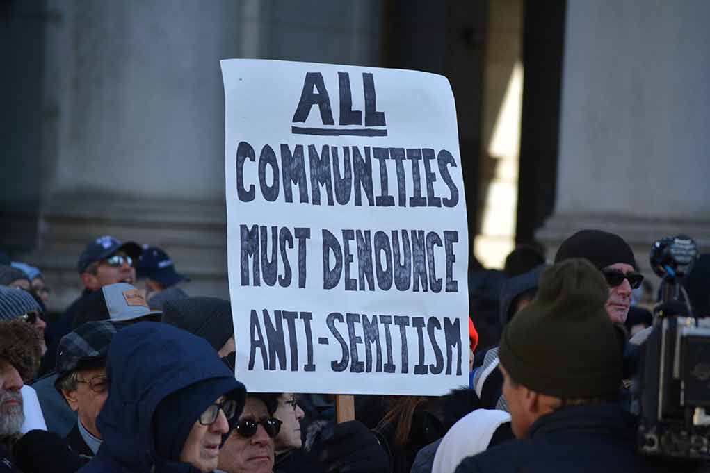 People holding sign against antiSemitism at protest