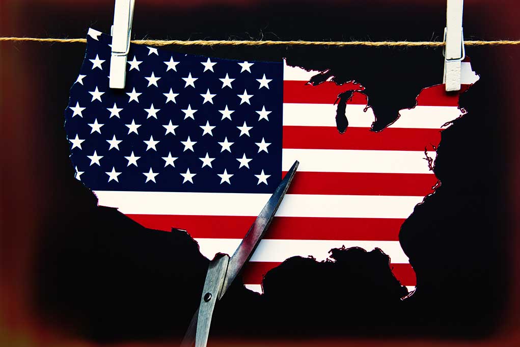1891378213 featured image Scissors cutting USA map with flag pattern.