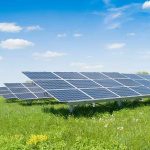USDA Revives Clean Energy Grants With Surprising Language Restrictions Solar panels in a grassy field under blue sky.