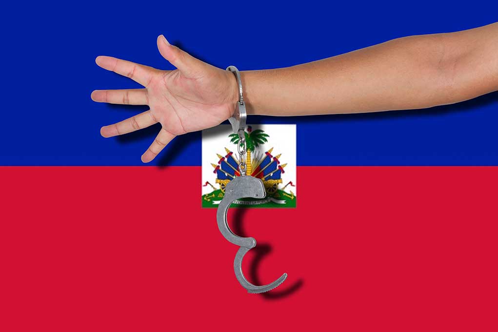 285923819 featured image person's arm with handcuffs in front of the flag of Haiti