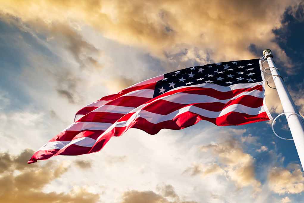 360951227 featured image American flag waving against a dramatic cloudy sky