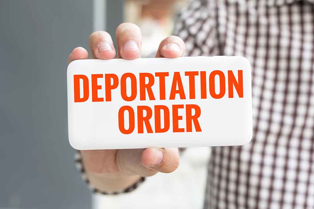 557935723 featured image Hand holding sign with Deportation Order text.