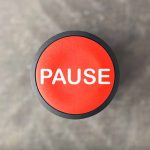 Trump Admin Pauses Federal Funding On Family Planning Services Red button labeled PAUSE on gray background.