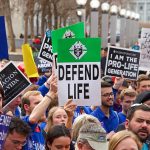 Controversial GOP Budget Plan Redirects Funds Away From Abortion Services Providers Pro-life rally with people holding various signs.