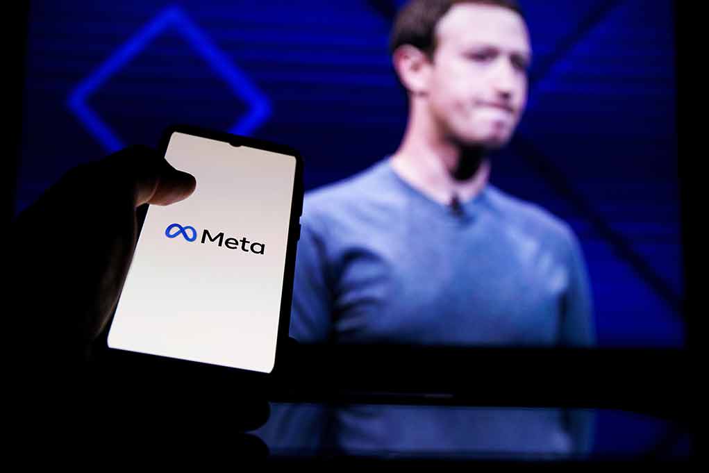 Hand holding phone displaying Meta logo screen