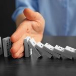 Virginia’s Bold Initiative To Tackle The Fentanyl Crisis Hand stopping falling row of dominoes.