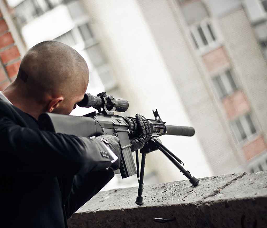555247681 featured image Person aiming a rifle from a building balcony