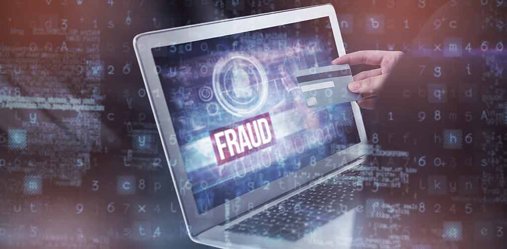 665585107 featured image Person holding credit card near laptop displaying Fraud