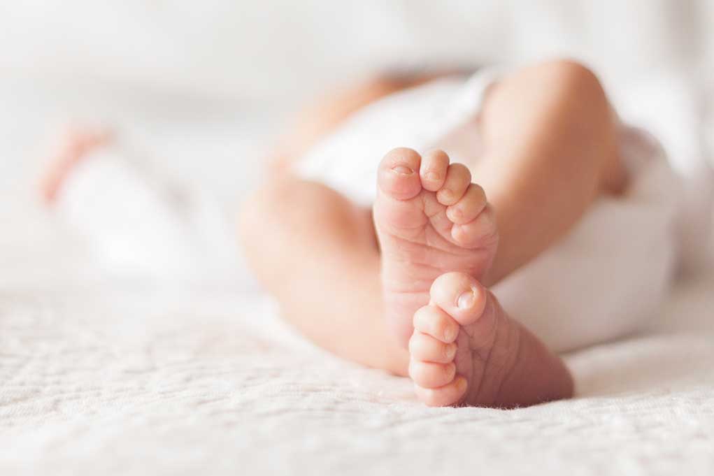 Close up of baby feet lying on blanket