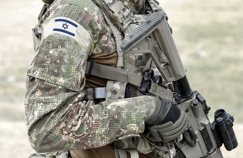 Soldier in camouflage gear with Israeli flag patch